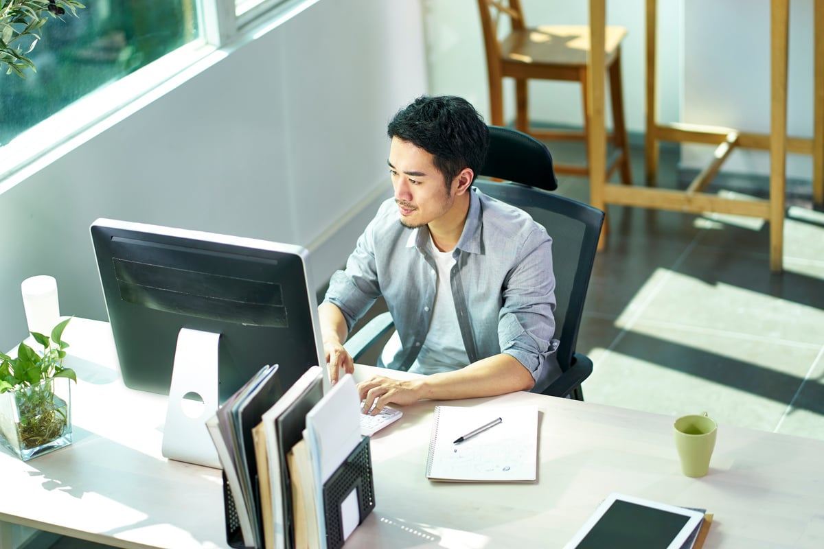 young asian business person working in office using computer