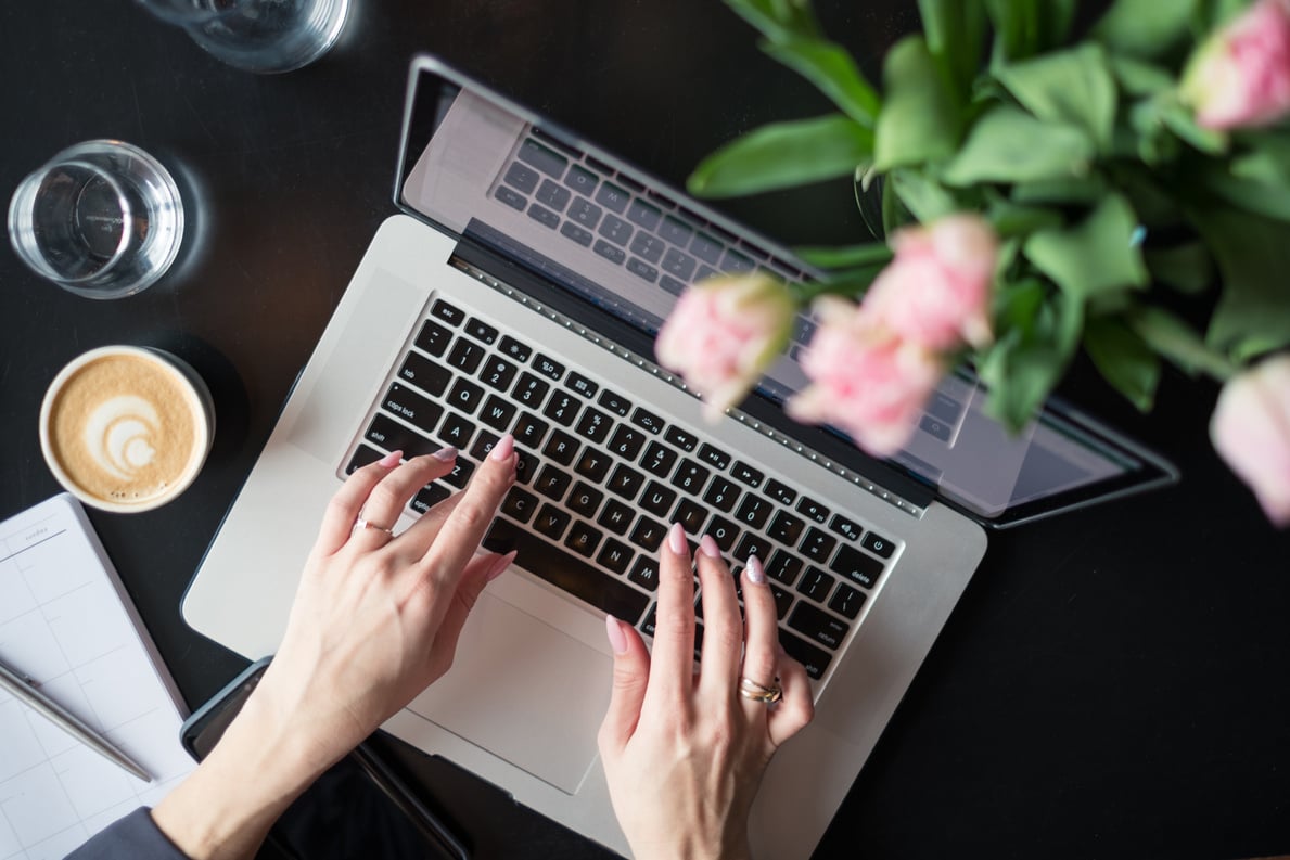 Overhead view of a female blogger writing on the laptop